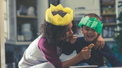 girl giving a biscuit to a boy